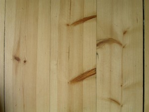 сравнение сосновой и еловой древесины: обе левые доски из сосны, а правая — еловая